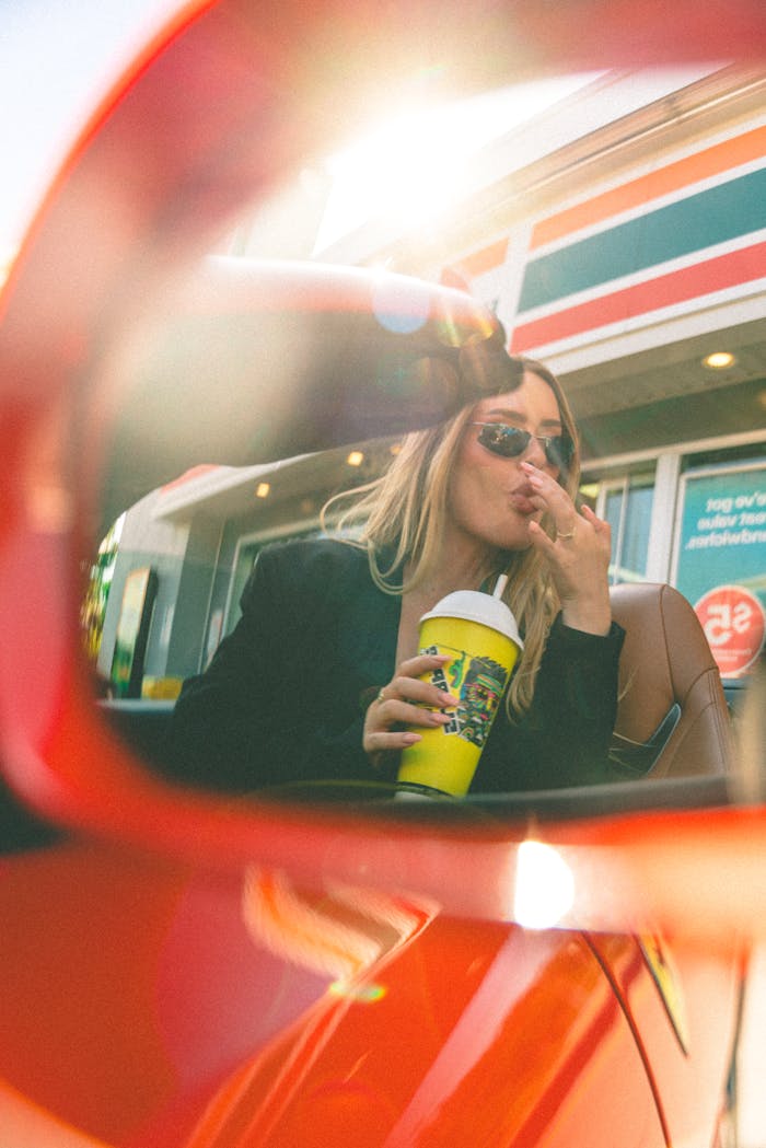 Blonde Girl Drinking and Eating Donut in Ferrari at a Gas Station