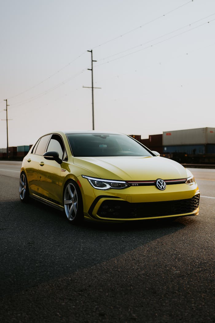 A yellow volkswagen golf r on the road